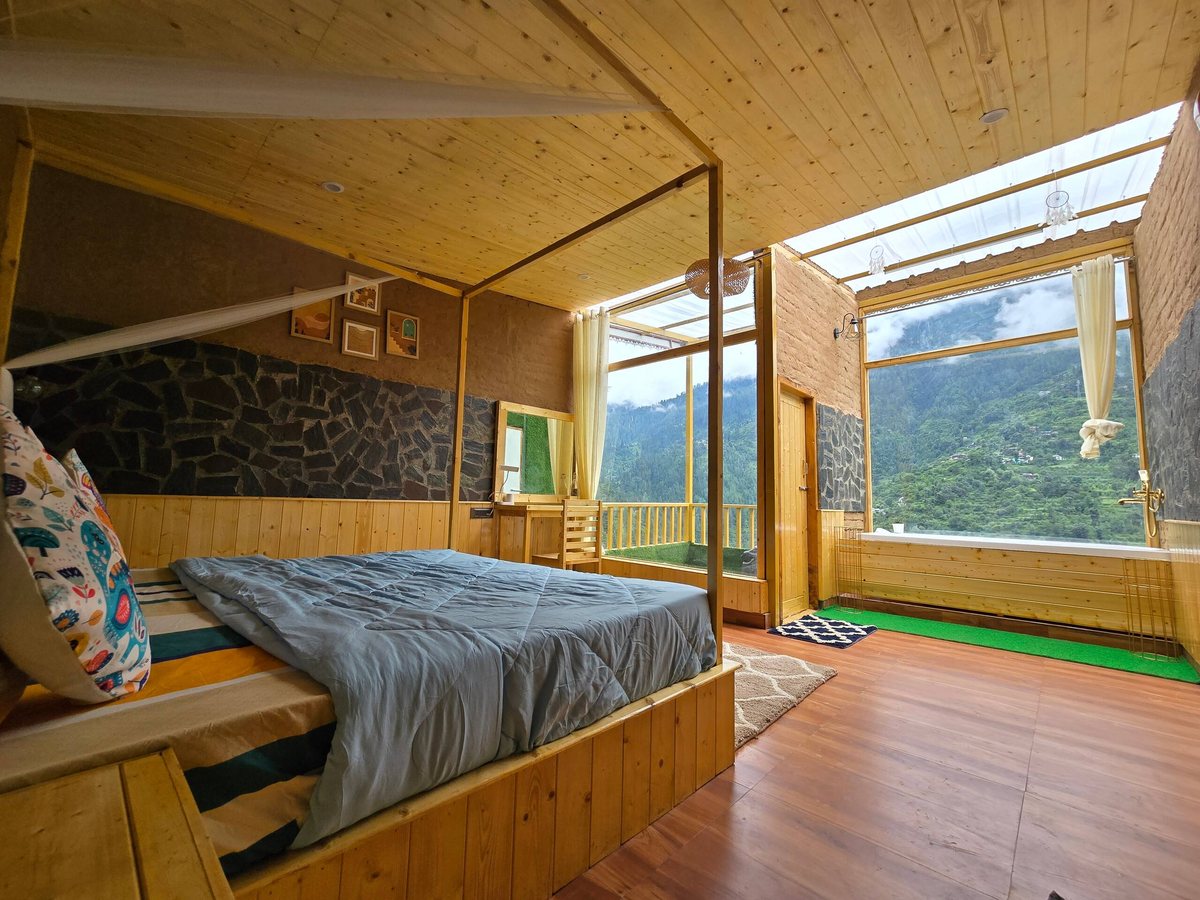 Glass House bed beside the glass wall with valley view