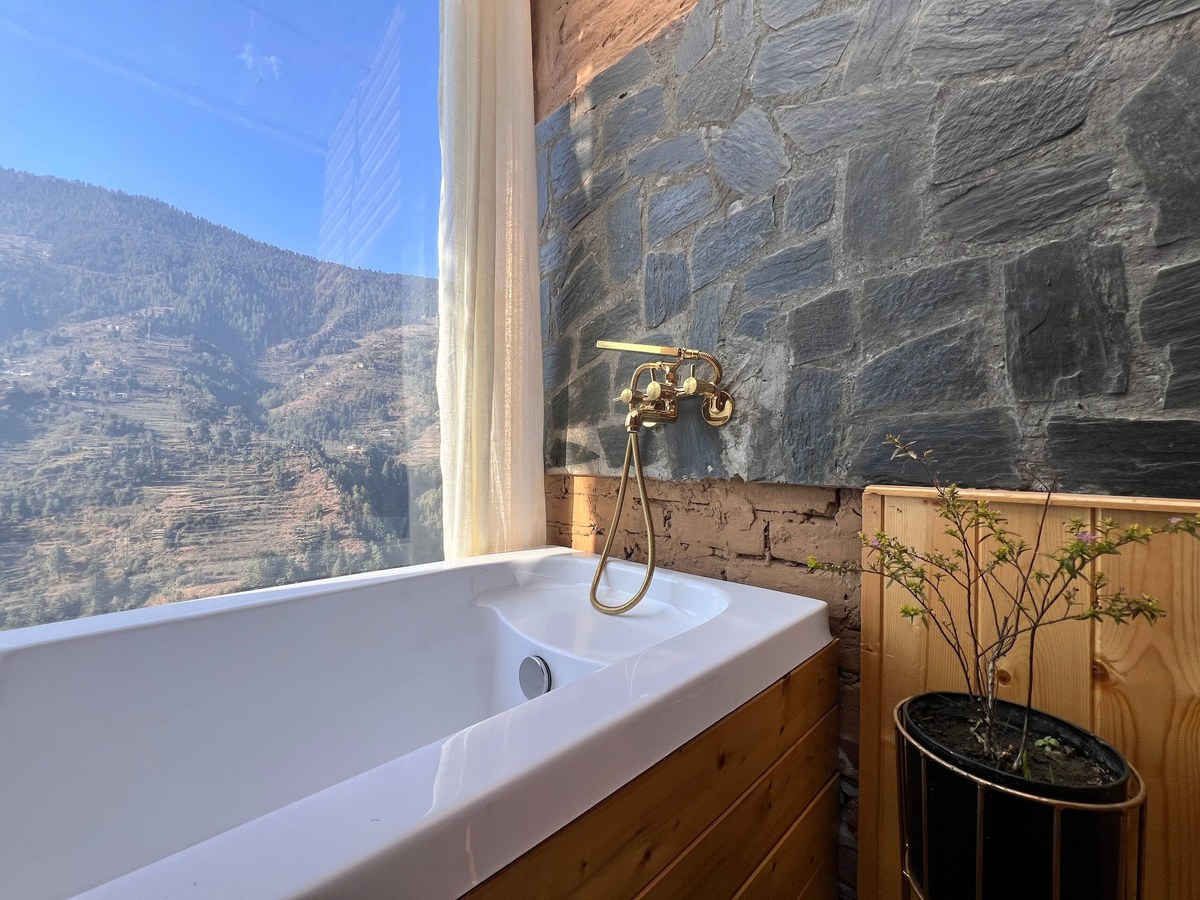 Private hot tub beside the glass with a mountain view